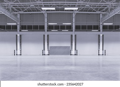 Roller Door Or Roller Shutter Using For Factory, Warehouse Or Hangar. Industrial Building Interior Consist Of Polished Concrete Floor And Closed Door For Product Display Or Industry Background.