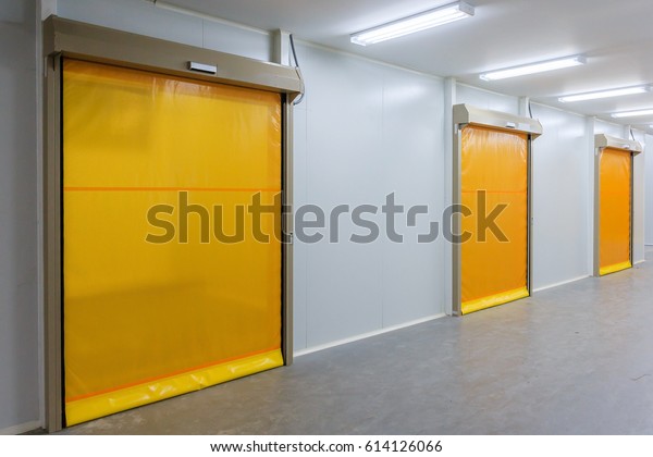 Roller shutter door and concrete\
floor inside factory building for industrial\
background.