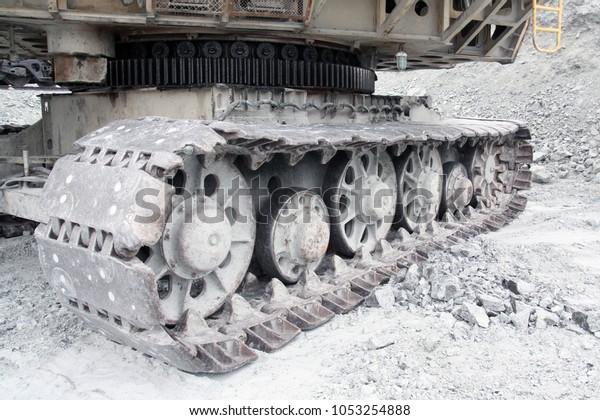 Roller wheel on a large excavator.\
Crown gear of\
a working excavator in a\
quarry.