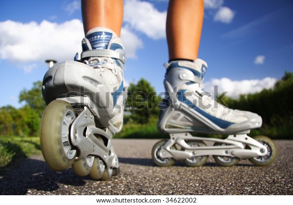 Rollerblades  inline skates closeup in action\
outdoors on sunny\
day.