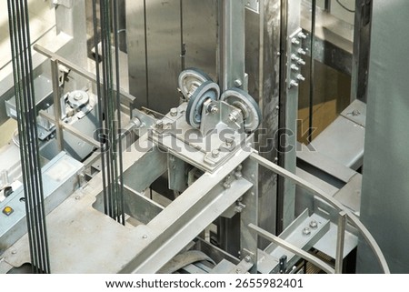 Rollers and cables at the top of the elevator cabin. Suspension of the passenger elevator cabin.                               
