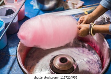 Rolling cotton candy in candy floss machine. Making candyfloss at market street.