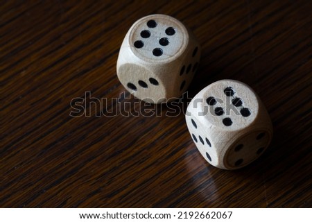 Rolling dices on a wooden table showing 12 points