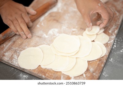 Rolling dumpling wrappers in kitchen