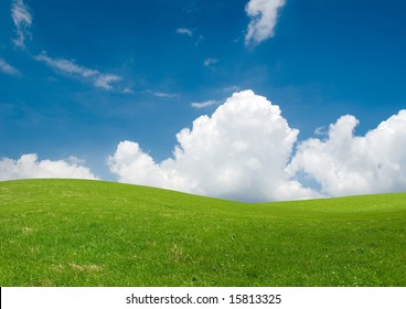 Rolling Green Hills Under A Blue Summer Sky.