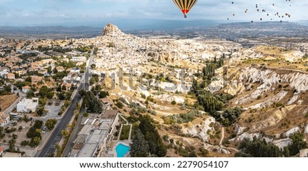 The rolling hills of Cappadocia's Pigeon Valley framed by the imposing Uchisar Castle create an awe-inspiring image with hot air flying balloons Foto stock © 