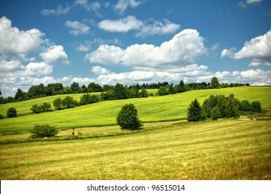 Rolling Hills Green Meadow With Trees On Sunny Summer Day With Blue Sky In Czech Republic