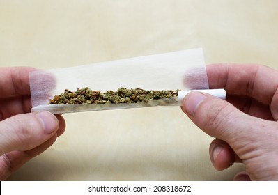 Rolling Marijuana Joint With Twoo Hands And Paper