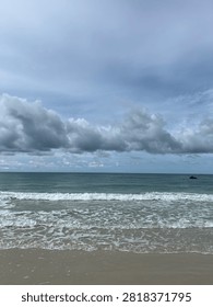 Rolling ocean waves and dramatic stormy cloudy sky on sandy beach
      Scenic view of gentle ocean waves rolling onto a smooth sandy beach under a dramatic overcast sky with heavy grey clouds. Peaceful coastal landscape and natural seascape background ideal for travel, weather, and nature concepts.