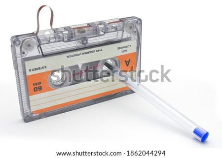 rolling up old cassette tape for recording music on white background