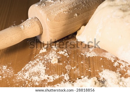 	 Rolling pin and the dough on a table with flour