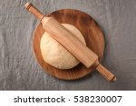 Rolling pin with dough  on wooden board