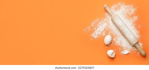 Rolling pin, flour and eggs on orange background with space for text - Powered by Shutterstock