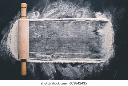 Rolling pin and white flour on a dark background. Free space for text . Top view. - Powered by Shutterstock