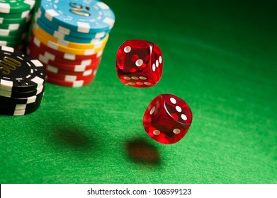 Rolling Red Dice On A Casino Table With Chips