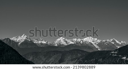 rolling snow mountains of meili range in black and white