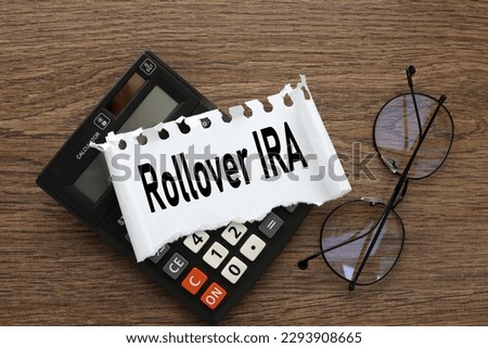 Rollover IRA. black calculator and torn paper with text