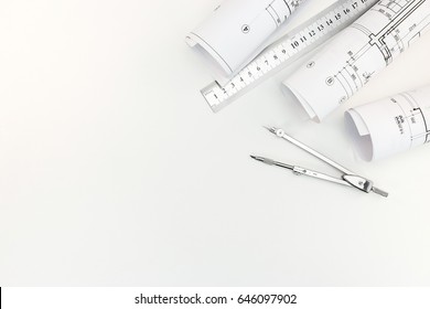 Rolls With Architectural Plans And Schemes With Drawing Compass And Metal Ruler On White Background Top View