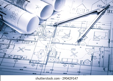 rolls of architecture blueprints and house plans on the table and drawing compass - Shutterstock ID 290429147