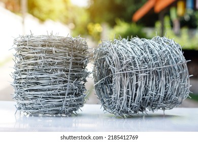 Rolls of barbed wire. Barbed wire is used for make fences , secure property and make border to show the territory of  area.                           