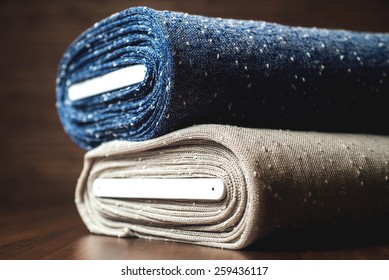 Rolls Of Blue And Brown Fabric On Wooden Background