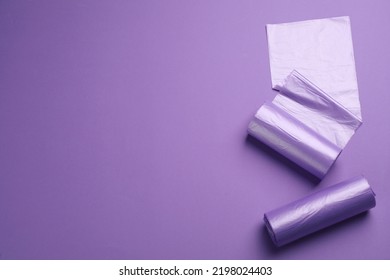 Rolls Of Color Garbage Bags On Violet Background, Flat Lay. Space For Text