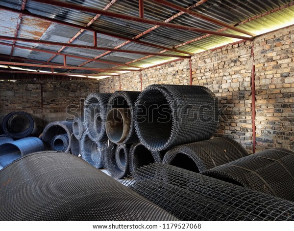 Rolls of metal meshes
in a sieve factory.