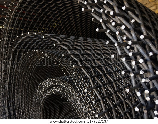 Rolls of metal meshes\
in a sieve factory.