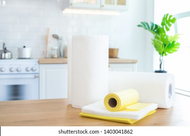 Rolls Of Paper Towels, Cleaning Wipes And Garbage Bags On The Table In The Kitchen With Sunlight.