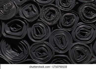 Rollen aus Plastiktüten. strukturierter Hintergrund für Tapeten. Viele schwarz aufgerollte Beutel für Bauabfälle.