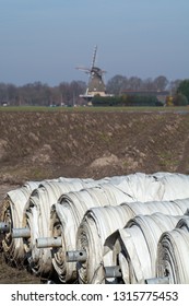 Rolls With Plastic Film For Covering White Asparagus Fields, Begin Of New Asparagus Season On Asparagus Farm In Netherlands, Country Spring Landscape With Traditional Dutch Mill