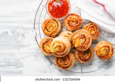 Rolls of puff pastry with bacon and cheese .