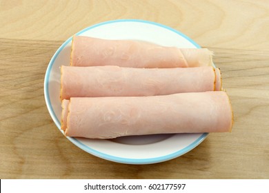 Rolls Of Smoked Honey Turkey Breast Meat On Plate For Snack Or Appetizer Preparation