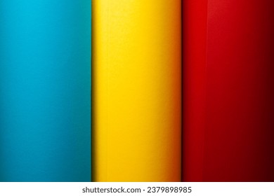 Rolls of splash paper for creativity. Three colours - light blue, lemon yellow, deep red. Text space. Studio shot