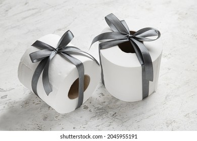 Rolls Of Toilet Paper With Ribbon On Light Background