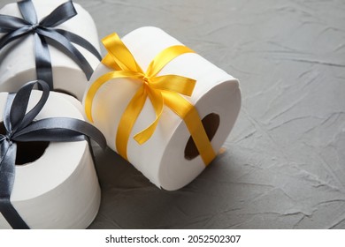 Rolls Of Toilet Paper With Ribbon On Dark Background, Closeup