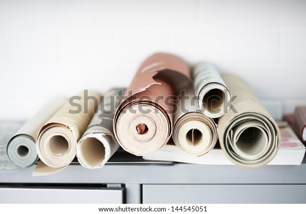 Rolls of wallpaper on\
desk