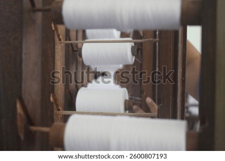 rolls of white thread inside a traditional weaving mill