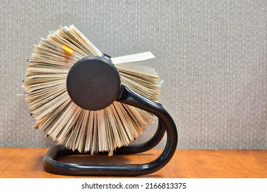 Rolodex file organizer sitting open on an office desk, side view with gray cubicle partition behind. - Shutterstock ID 2166813375