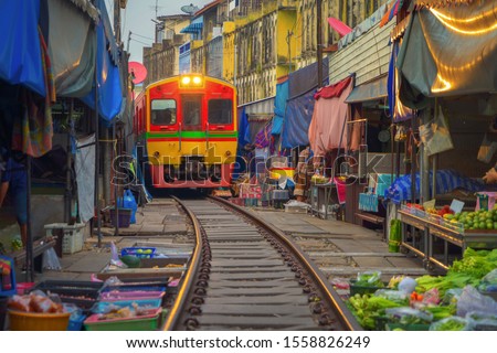 Rom Hoop market. Thai Railway with a local train run through Mae Klong Market in Samut Songkhram Province, Thailand. Tourist attraction in travel and transportation concept.