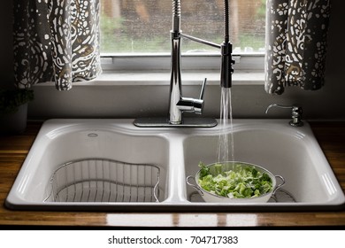 Romaine Lettuce Being Washed In White Sink With Running Water