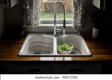 Romaine Lettuce Being Washed In White Sink With Running Water