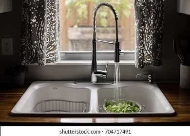 Romaine Lettuce Being Washed In White Sink With Running Water