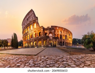 Roman Coliseum illuminated at sunrise, summer view without people, Rome, Italy