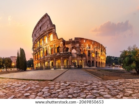 Roman Coliseum illuminated at sunrise, summer view without people, Rome, Italy