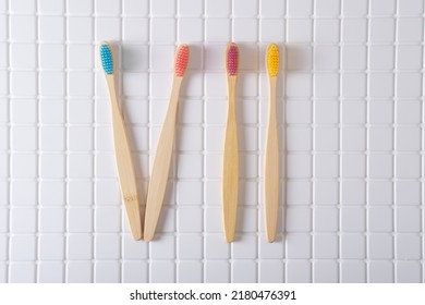 Roman numeral VII composed of toothbrushes on a white tiled background. Decoration bathroom