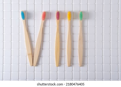 Roman numeral VIII composed of toothbrushes on a white tiled background. Decoration bathroom