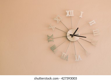 Roman numeral wall clocks on Peach color wall, thirteen o'clock seventeen minutes