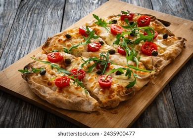 Roman pinsa with mozzarella cheese, capers, arugula and garlic on wooden table  - Powered by Shutterstock