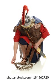 Roman Soldier Picking Up A Crown Of Thorns Isolated On A White Background